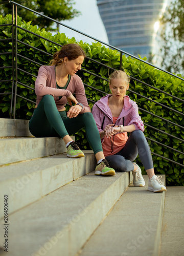 Two friends sit on steps an...