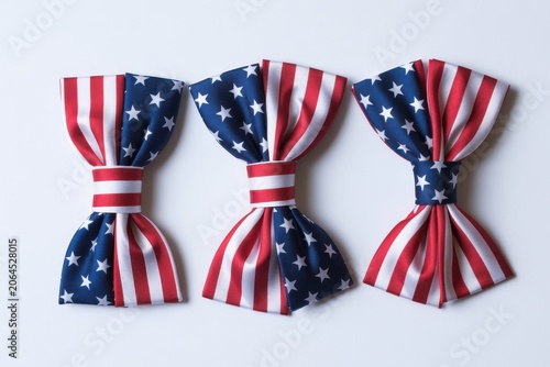 Three American flag bow ties arranged in a row on a clean white background with soft lighting