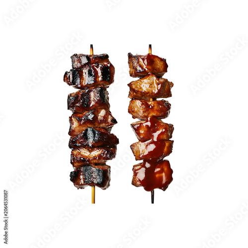 Two skewers of grilled glazed meat chunks