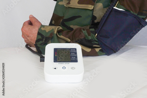 Bild auf Leinwand Veteran Taking Blood Pressure Reading Shows High Systolic and Diastolic Numbers
