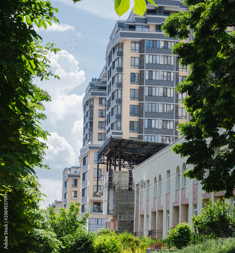 Foto Modern residential apartment buildings surrounded by lush green trees under a br