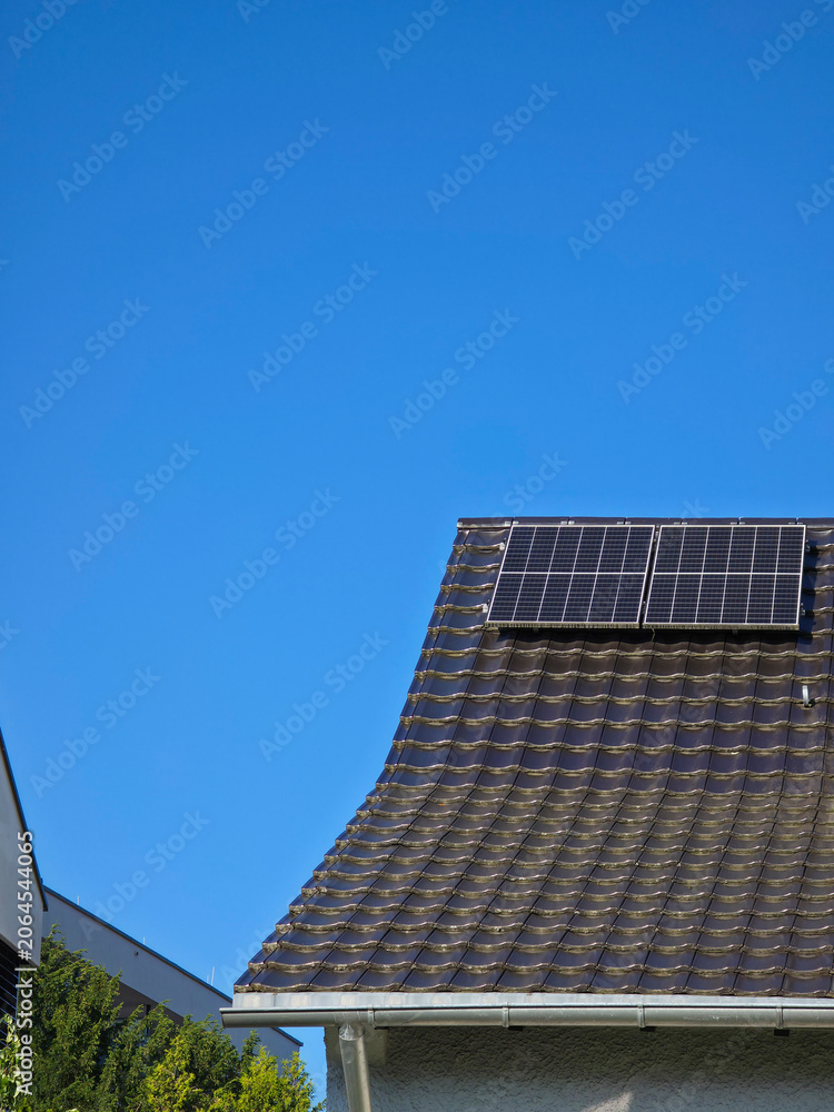 Fototapeta premium two pv modules on house roof generating clean energy efficiently under brilliant deep blue sky
