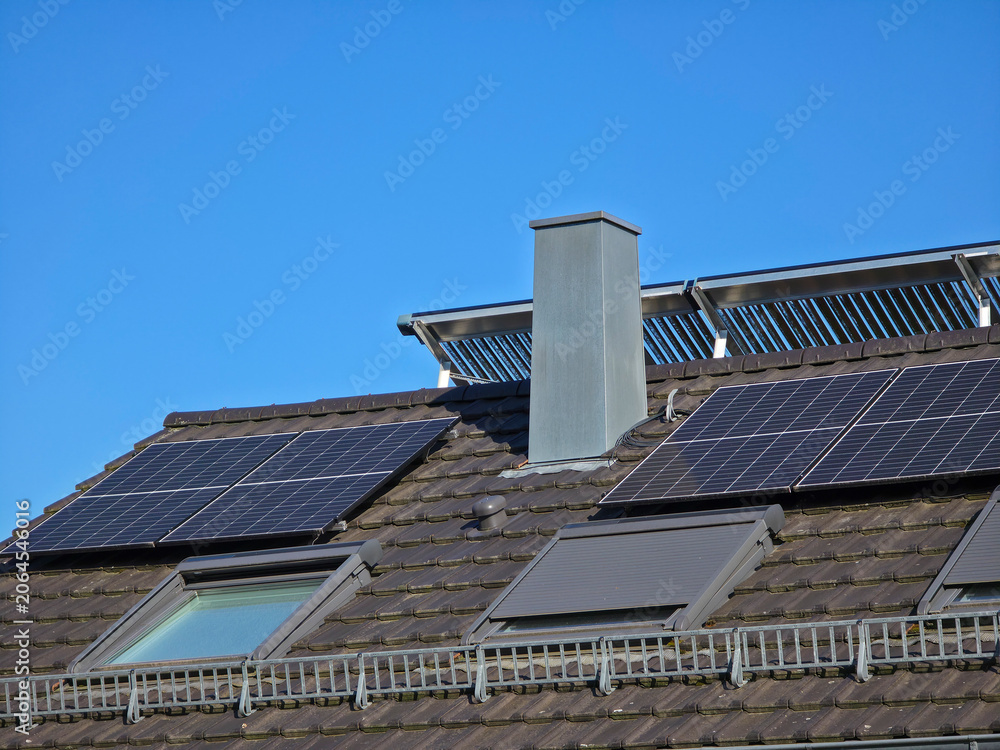 Fototapeta premium pv modules beside roof windows creating efficient renewable energy solution under radiant deep blue sky