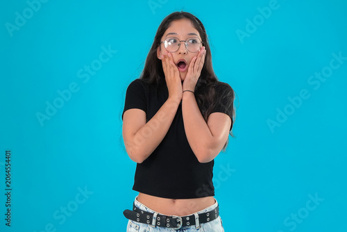 Woman looking surprised with hands on cheeks in studio