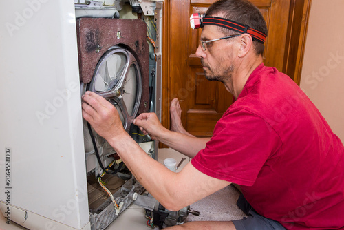 A man repairs a washing machine himself.