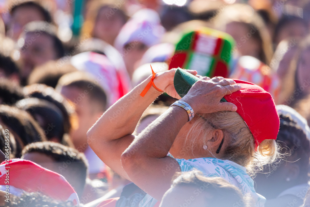 Naklejka premium Portugal soccer fan wearing patriotic hat cheering in crowd