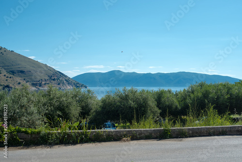 Photography Sea and mountains with lush vegetation and road in foreground