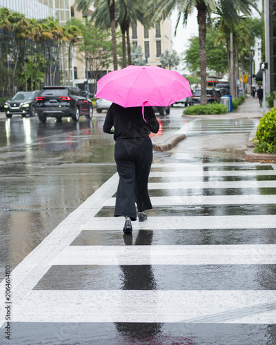 Woman Walking with Pink Umbrella on Rainy City Street