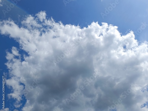 Dense white and grey cumulus cloud filling a blue sky. Daytime weather and meteorology background