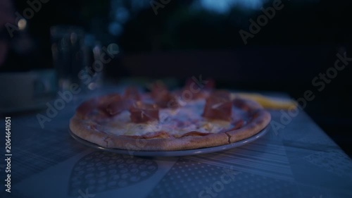 Close up view of a prosciutto pizza with melted cheese served on a table in Zagreb, Croatia.