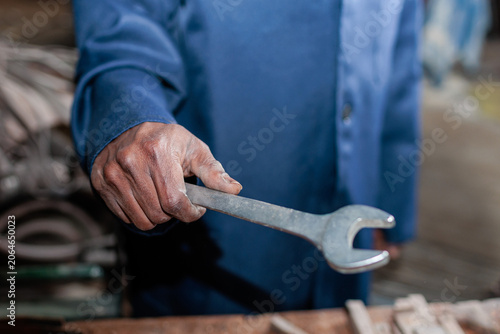 Closeup of worker holding a wrench in a workshop