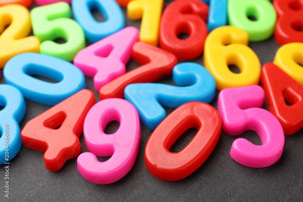 Fototapeta premium Different colorful numbers on black table, closeup