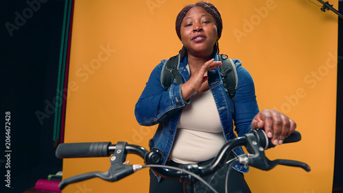 Fotografie Video showcasing African American bike messenger happily explaining about her co