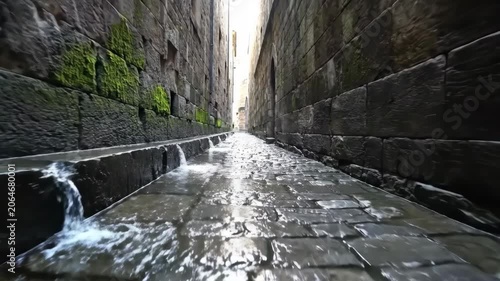 Ancient Stone Water Channel Flowing Through Narrow Alleyway with Mossy Walls.
