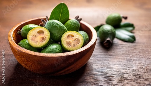 green feijoa fruit slice feijoa leaf acca sellowiana in bowl on wooden background tropical feijoa or pineapple guava fruit exotic green fruit raw acca sellowiana plant guavasteen green fruit