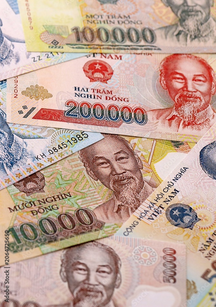 Fototapeta premium Vietnamese dong money bills pile on table. Vietnam banknotes of VND currency close up.