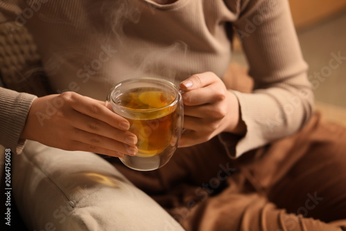 Woman holding steaming glas...