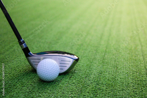 Golf Club and White Ball on a Green Turf Surface Ready for Swing