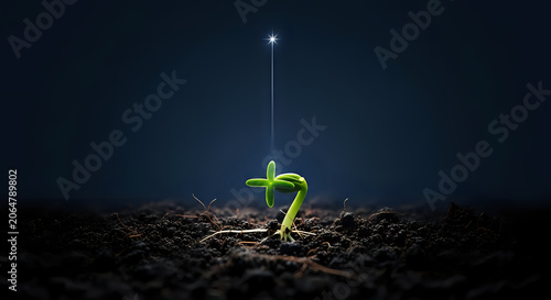 Green sprout growing from dark soil illuminated by a sharp beam of light with beginning