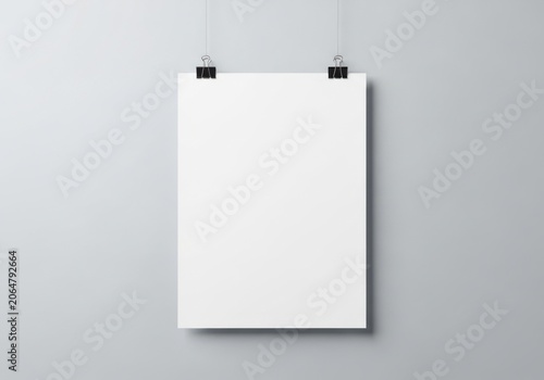 Blank white poster mockup hanging on a grey wall