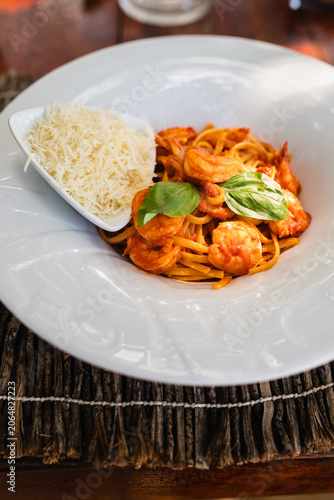 Vertical shot of Italian shrimp pasta with tomato sauce and grated parmesan cheese.