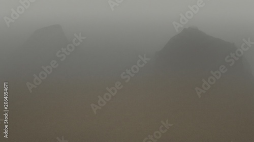 Minimalist Foggy Landscape with Distant Rock Silhouettes