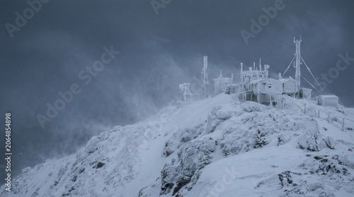 Frozen Weather Station on Snowy Mountain Peak During Blizzard