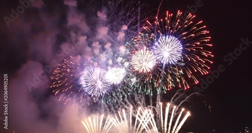Spectacular fireworks display lighting up the night sky over a festive celebration by the water