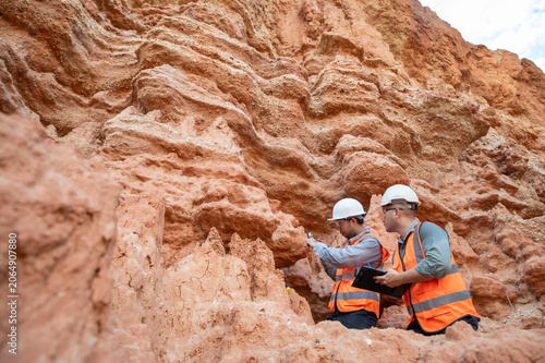 Cuadro en lienzo Expert geologists are collaborating to examine the rock formations to analyze the water flow from the cliffs