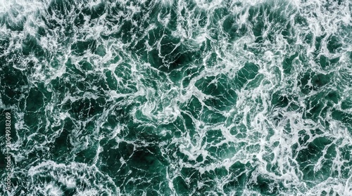 Aerial view of turbulent dark green ocean water with white foam and swirling patterns creating a dramatic seascape texture
