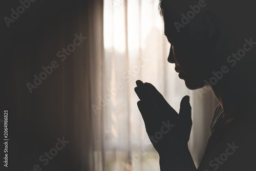 Canvas Print Silhouette of a woman praying at sunset, expressing faith, hope, and spiritual devotion