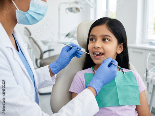 indian girl receiving dental examination for pediatric dentistry oral healthcare and preventive dental care concept