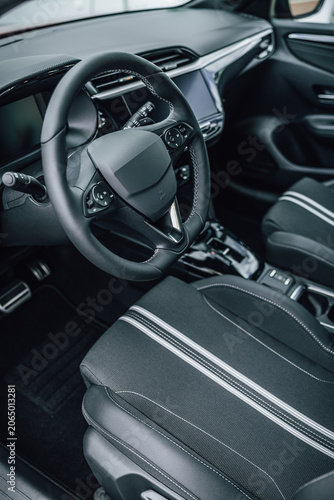 Modern car interior with focus on steering wheel and upholstered seats
