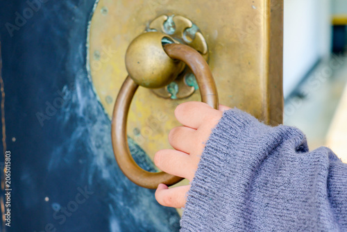Fotografie Hand grips a weathered brass ring