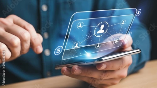 Futuristic Interface Interaction A person's hands interact with a sleek transparent smartphone displaying a futuristic interface with interconnected user profiles and icons