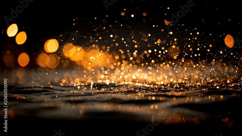 Abstract golden bokeh and sparkling particles on dark water.