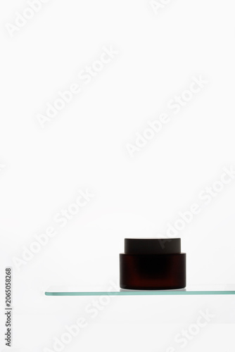 ?ilhouette cosmetic container with shadow at white background. Modern skincare packaging design for high-end cream or face moisturizer.
