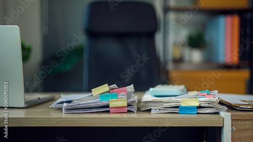 Bild auf Leinwand Cluttered desk holds stacks of papers and colorful sticky notes