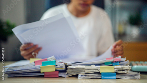 Принти на полотні Busy professional reviews documents at cluttered desk