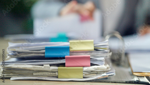 Φωτογραφία Stacked papers secured with colorful clips
