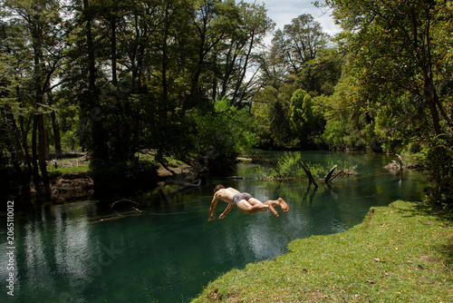 Man diving headfirst into a green river
