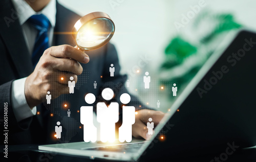 Bild auf Leinwand Business recruitment and talent acquisition concept featuring a professional using a magnifying glass to identify qualified candidates on a digital network