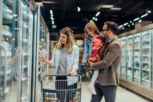 Фотография Family shopping for food in the supermarket freezer aisle