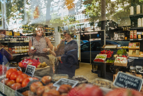 Tableau sur toile Women shopping for organic food products at supermarket