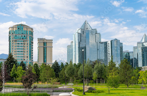 Modern Nurly Tau business district skyline in Almaty viewed from former presidential residence park on Nazarbayev avenue under blue summer sky