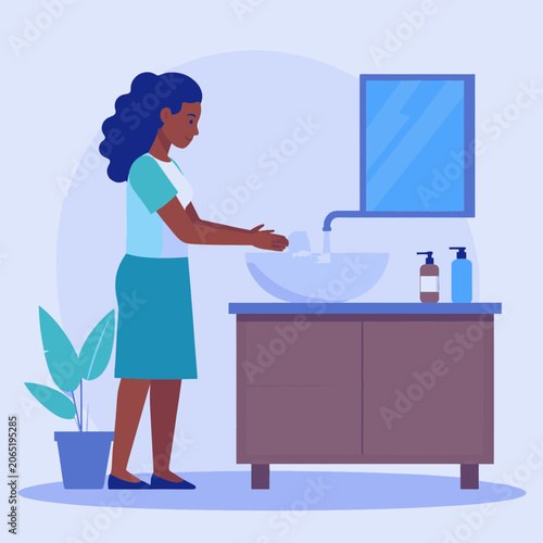 A woman washes her hands at a sink