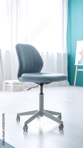 Creative design studio with a light gray ergonomic office chair featuring a soft lumbar cushion, set in an airy modern workspace. 