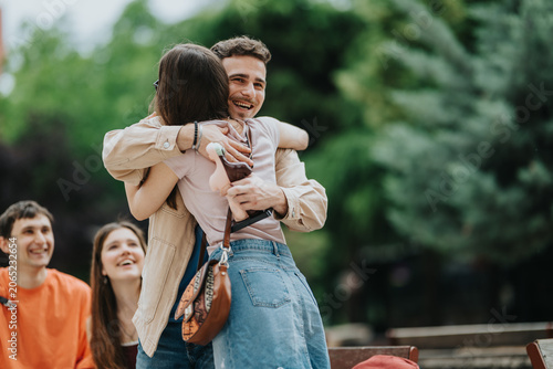 Foto Two students hug warmly while friends look on with happy expressions