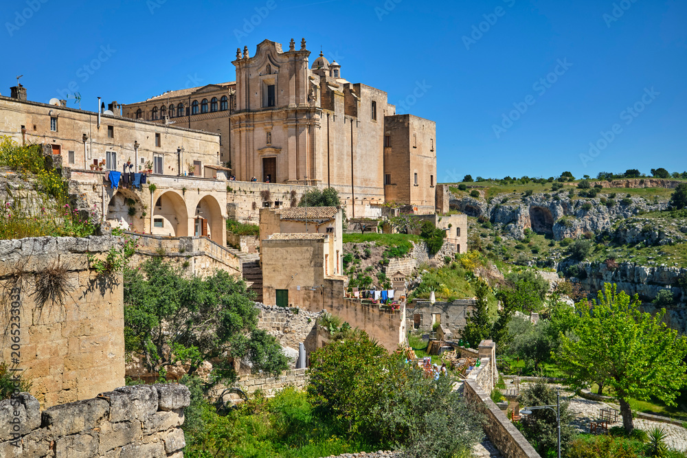 Obraz premium street view in the medieval city of Matera, Basilicata, Italy, featuring historic stone buildings, ancient architecture, under a clear blue sky in the UNESCO World Heritage 