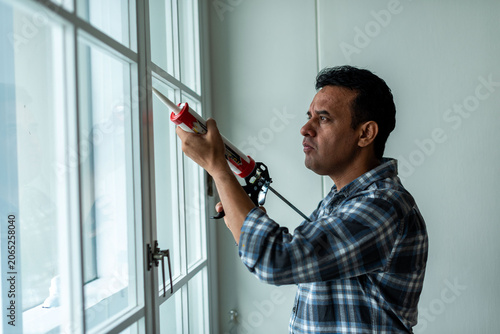 Photography Man sealing window frame photo